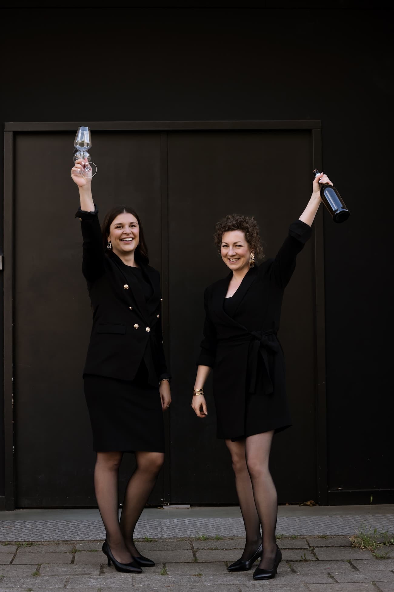 Rachelle en Tamara proosten met een fles in de hand